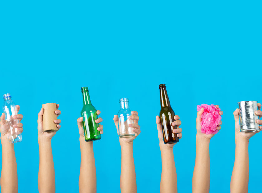 many hands holding many kind of garbage on blue background